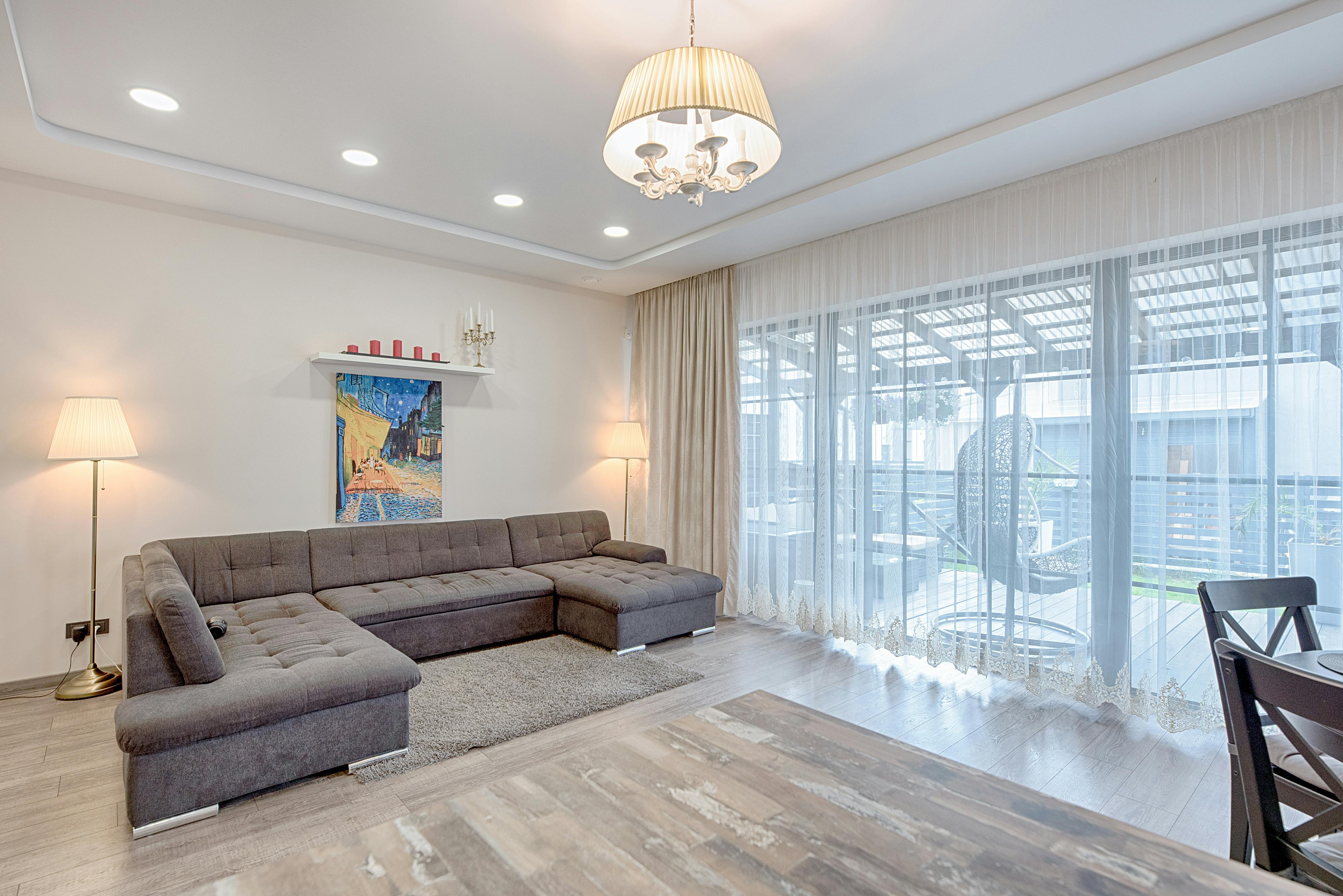 Wohnzimmer mit Ecksofa und großem Panoramafenster